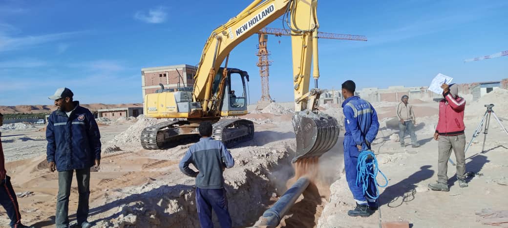 Pelle New Holland remblayant une tranchée de canalisation