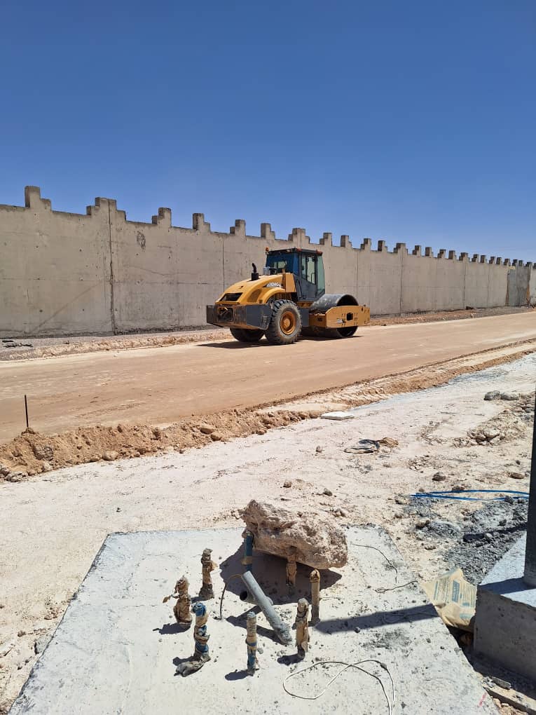 Compactage d'une voie le long d'un mur d'enceinte